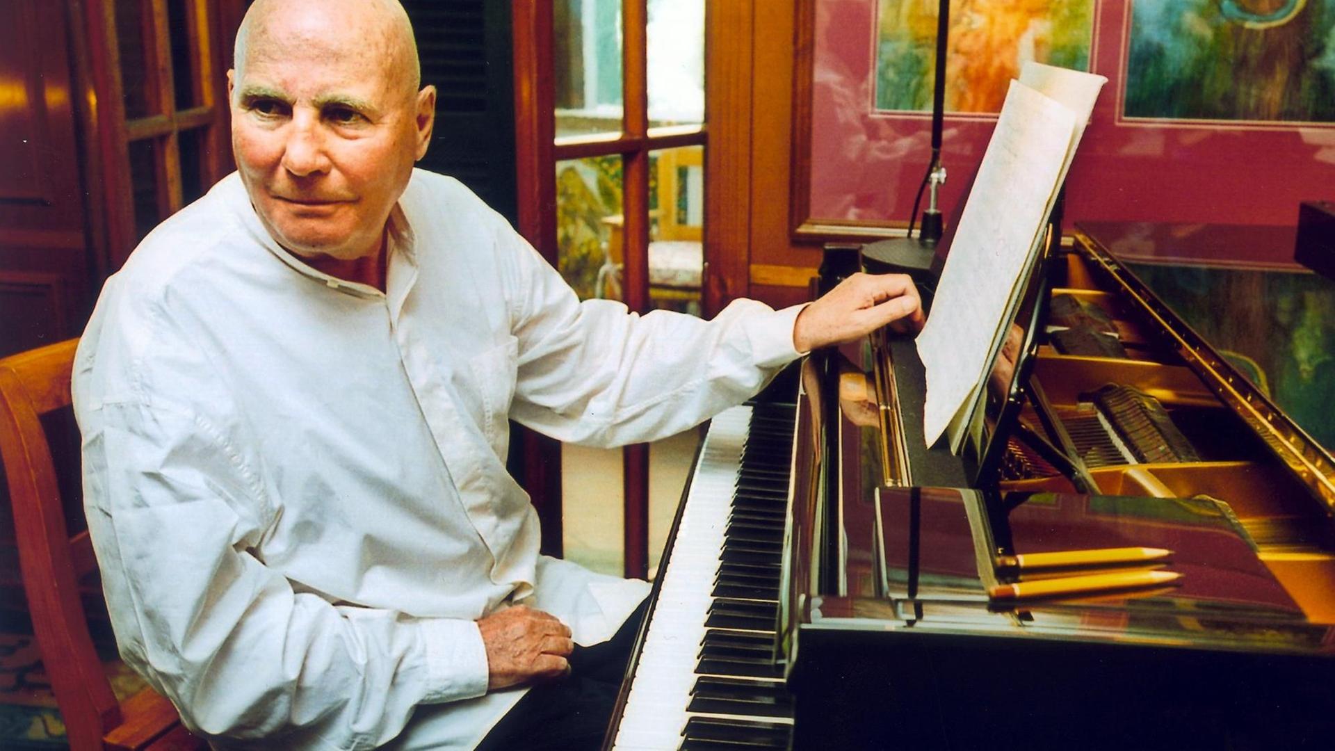 Der deutsche Komponist Hans Werner Henze sitzt an einem Klavier 