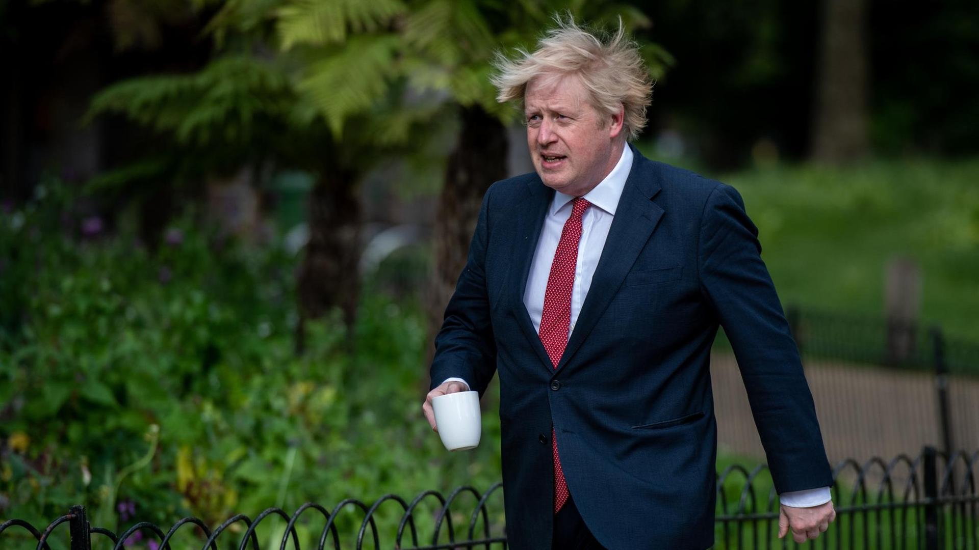 Boris Johnson geht durch den Park.
