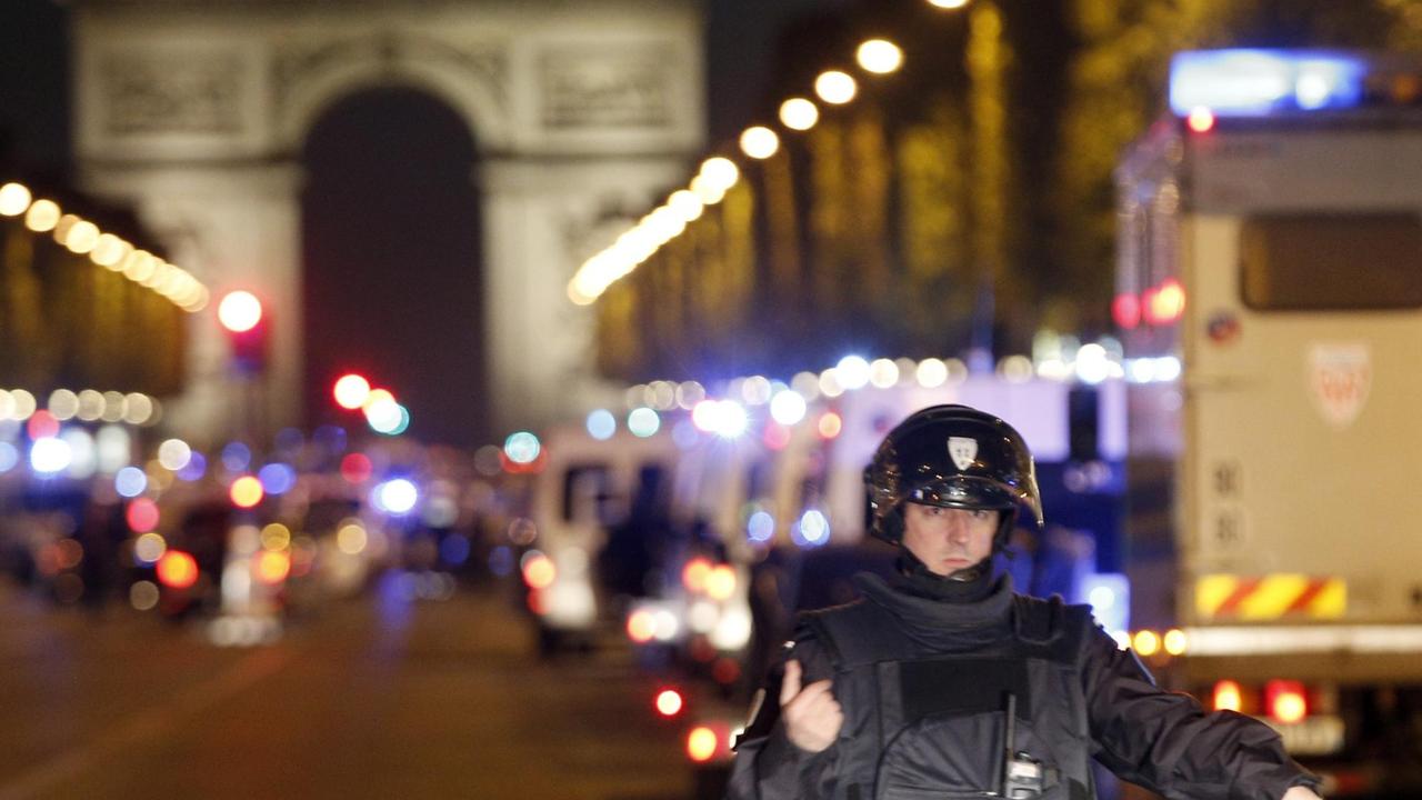 Polizisten blockieren die Einfahrt zum Pariser Boulevard Champs-Élysées. Dort sind Polizisten angegriffen worden.