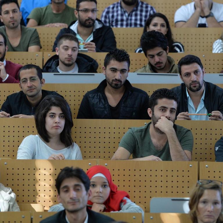 Studentinnen und Studenten sitzen am 04.10.2016 in Bremen bei einer Einführungsveranstaltung der Universität in einem Hörsaal. Sie sind Flüchtlinge aus verschiedenen Ländern, vor allem aber aus Syrien. Alle haben einen akademischen Hintergrund und zuvor das Bewerbungsverfahren durchlaufen.
