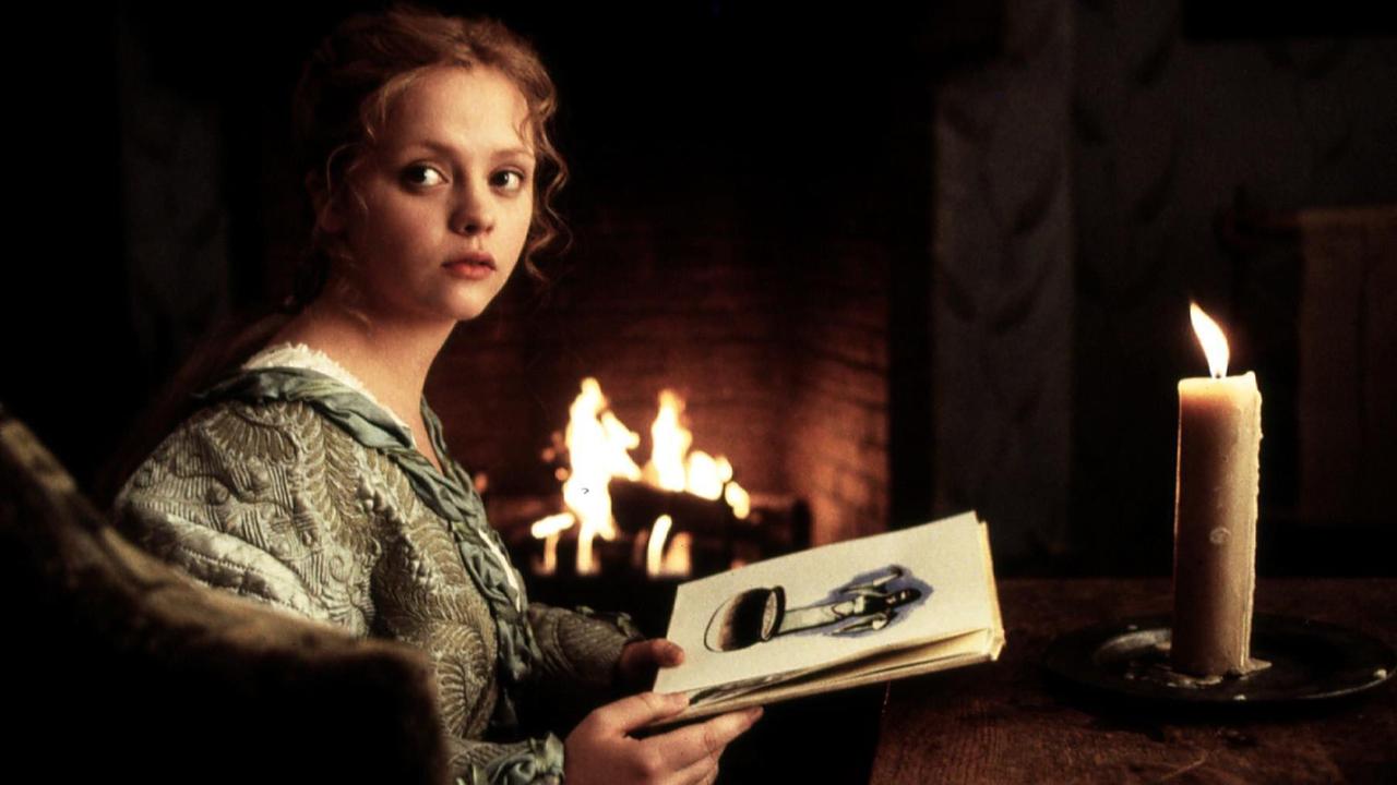 Filmszene aus "Sleepy Hollow": Eine Frau sitzt neben einem Kamin, Papier mit einer Zeichnung in der Hand, vor sich eine große Kerze. Sie schaut unsicher in Ruchtung des Betrachters.