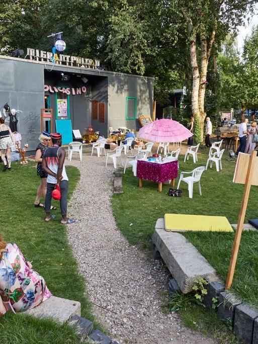 Veranstalter und Besucher sitzen während des Internationalen Sommerfestivals des Theaters Kampnagel in Hamburg im dafür gestalteten Garten.