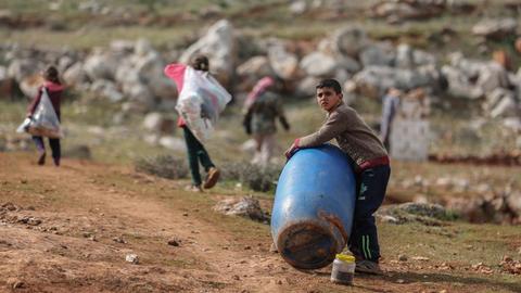 Ein syrischer Junge hält ein Plastikfass in der Nähe eines behelfsmäßigen Lagers für Familien, die infolge der Bombardierung und der Militäroperationen aus dem Idlib-Land vertrieben wurden.