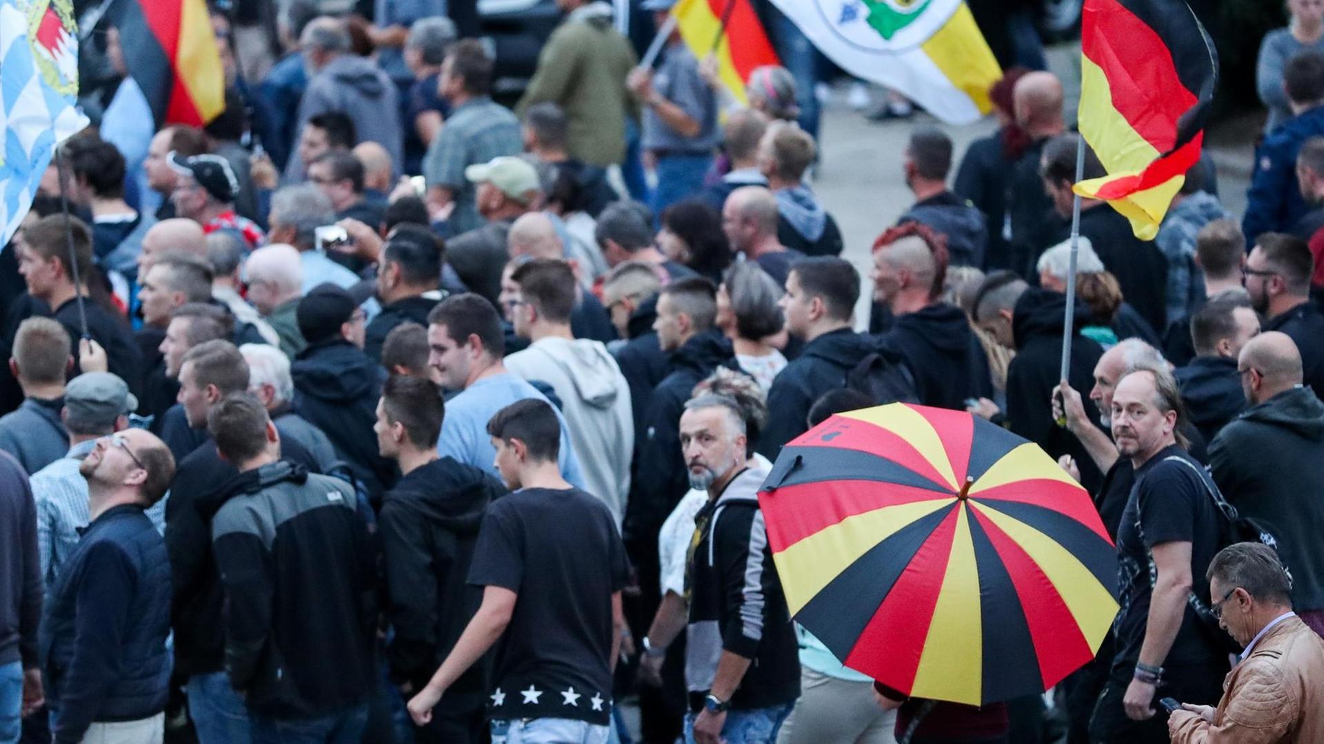 Demonstranten der rechten Szene bei einer Veranstaltung im August in Chemnitz mit Deutschland-Fahnen und Schirmen
