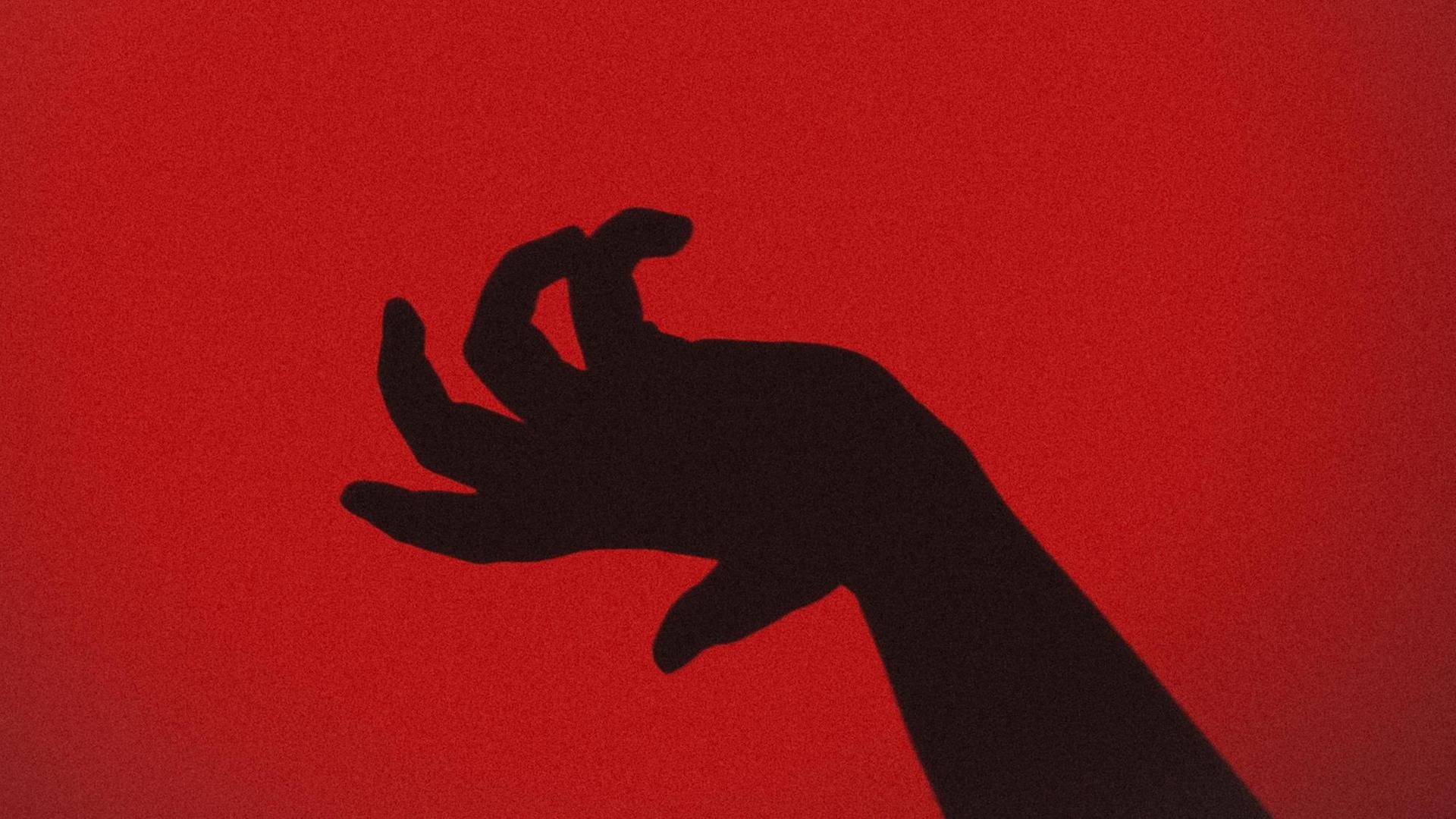 Die Silhouette einer Hand vor einem roten Hintergrund