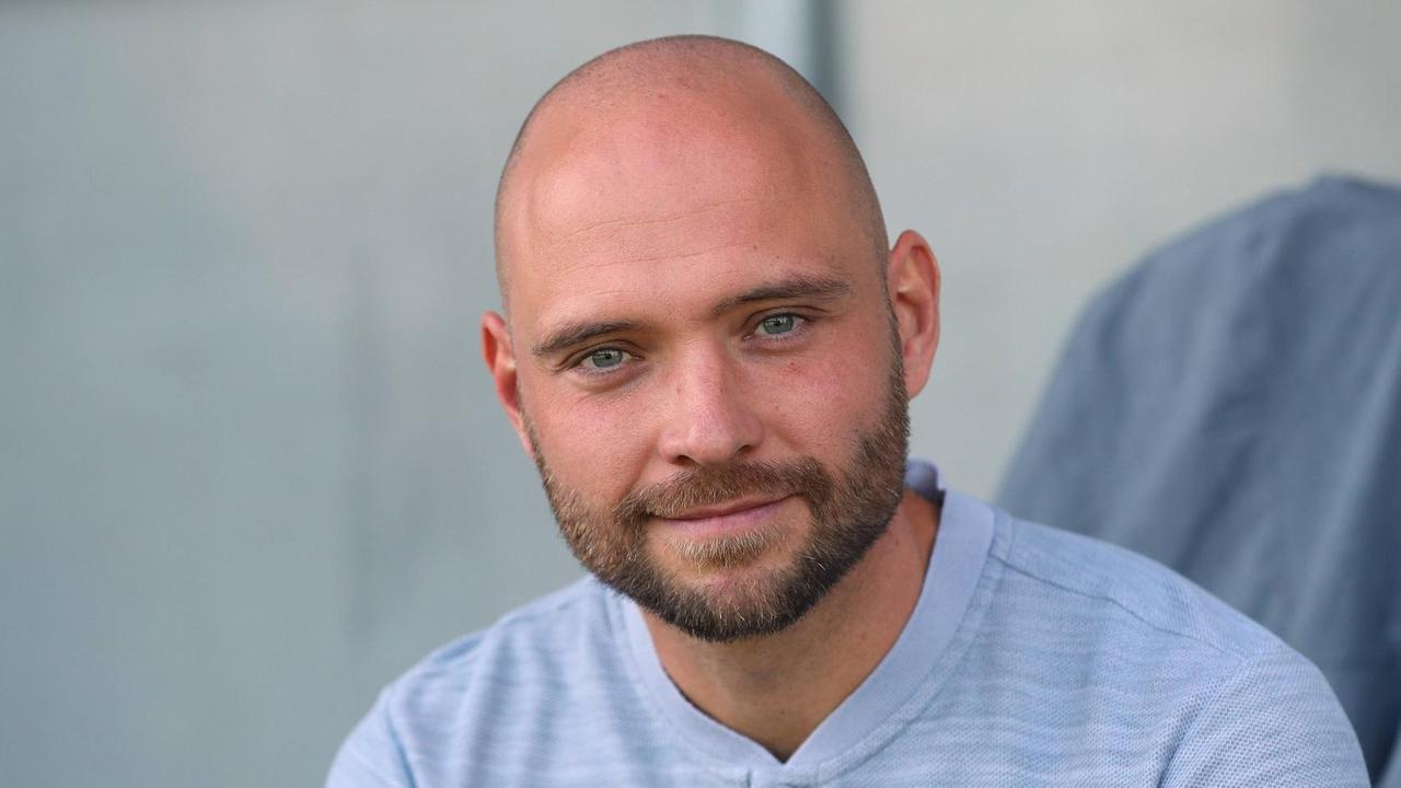 Stephan Lerch trainiert wieder die Frauen des VfL Wolfsburg. Er ist im Portrait zu sehen, trägt ein helles T-Shirt und lächelt in die Kamera. Stephan Lerch trainiert wieder die Frauen des VfL Wolfsburg. Er ist im Portrait zu sehen, trägt ein helles T-Shirt und lächelt in die Kamera.