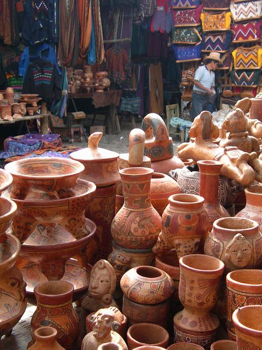 Blick auf traditionelle Tonwaren und Textilien auf einem Markt in Chichicastenango in Guatemala