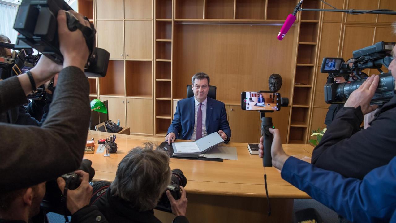Markus Söder (CSU), Ministerpräsident von Bayern, sitzt am 16.03.2018 nach seiner Wahl in der bayerischen Staatskanzlei umringt von Kameras an seinem neuen Arbeitsplatz
