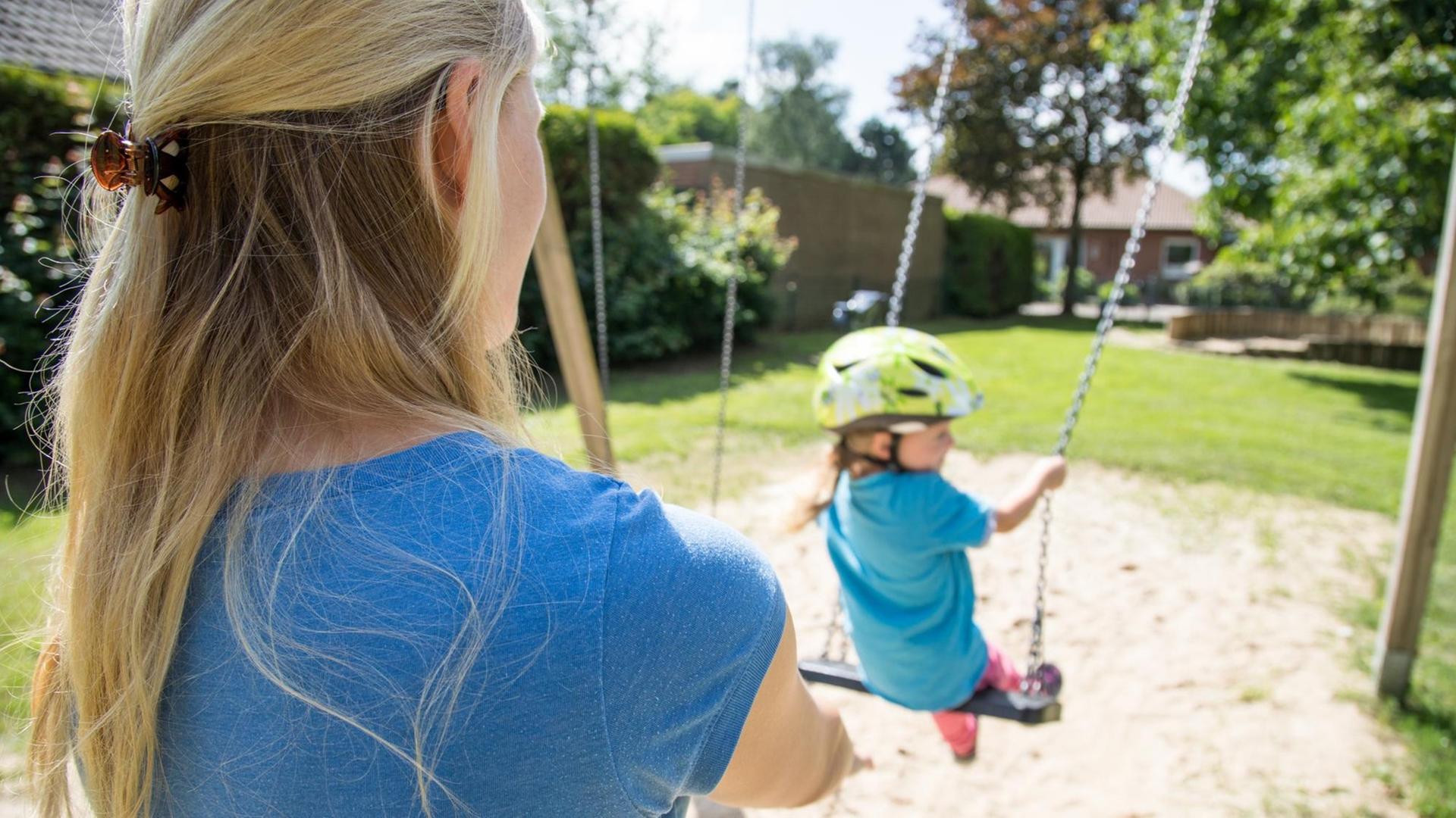 Eine Frau in Nottensdorf (Niedersachsen) mit ihrer kleinen Tochter auf dem Spielplatz (gestellte Szene). Foto: Christin Klose | dpa Themendienst | Verwendung weltweit