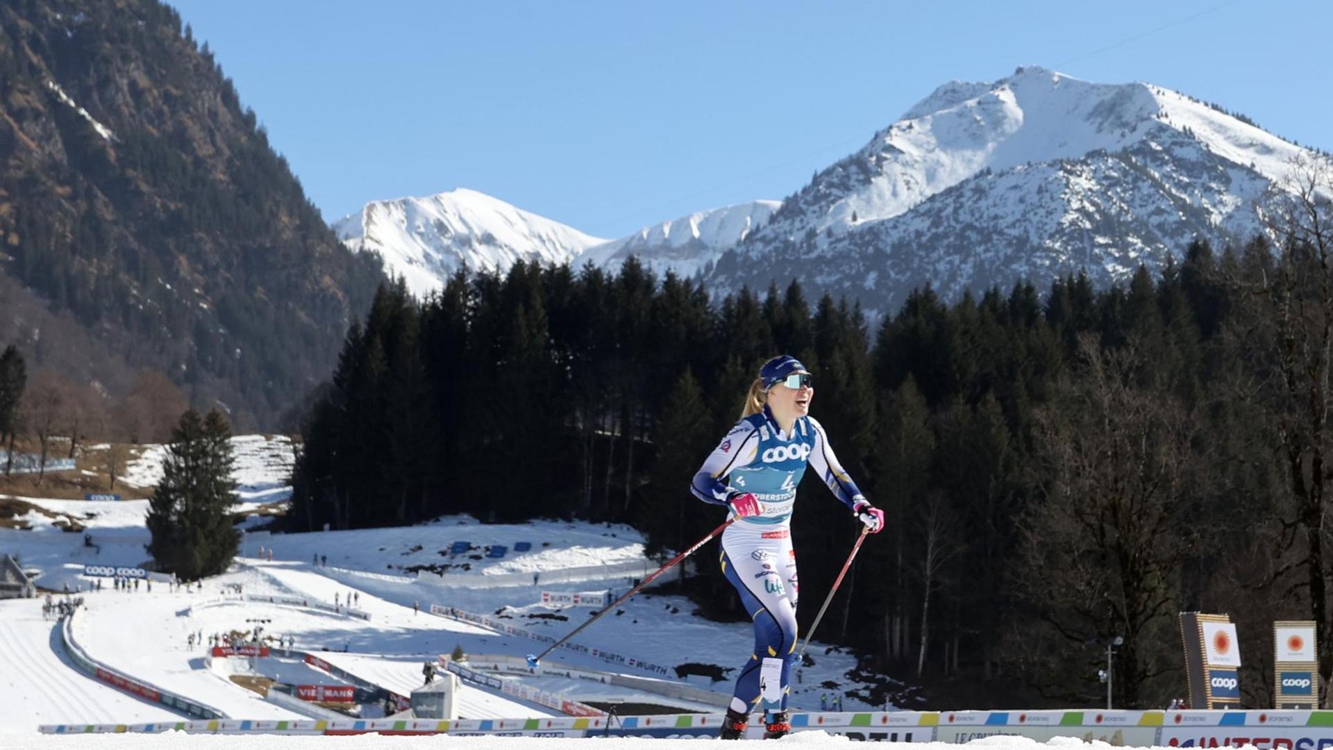 Jonna Sundling aus Schweden jubelt im Ziel im Finale über den Sieg, im Hintergrund das Bergpanorama Oberstdorfs