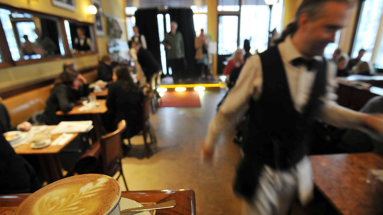 Blick in ein Restaurant: ein Kellner läuft durchs Bild.