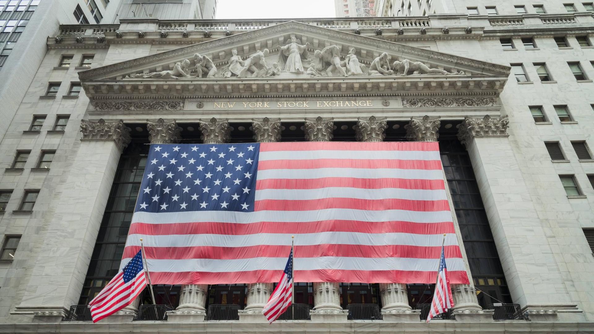 Sie sehen eine US-amerikanische Flagge vor der Börse in New York City