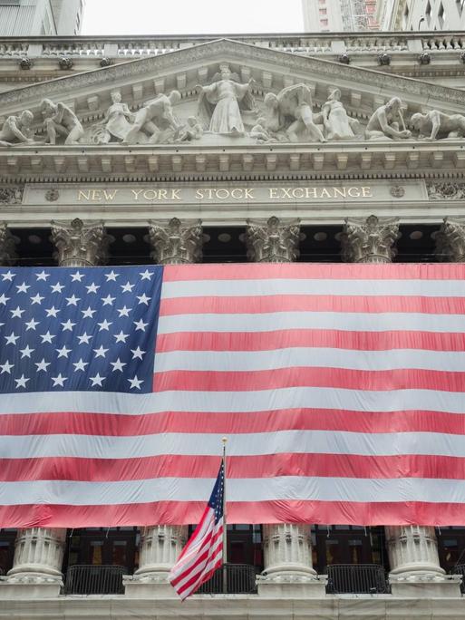 Sie sehen eine US-amerikanische Flagge vor der Börse in New York City