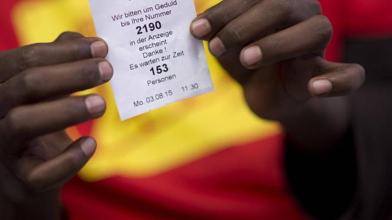 Ein Asylsuchender aus Somalia mit seiner Wartenummer in der Zentralen Aufnahmeeinrichtung des Landes Berlin