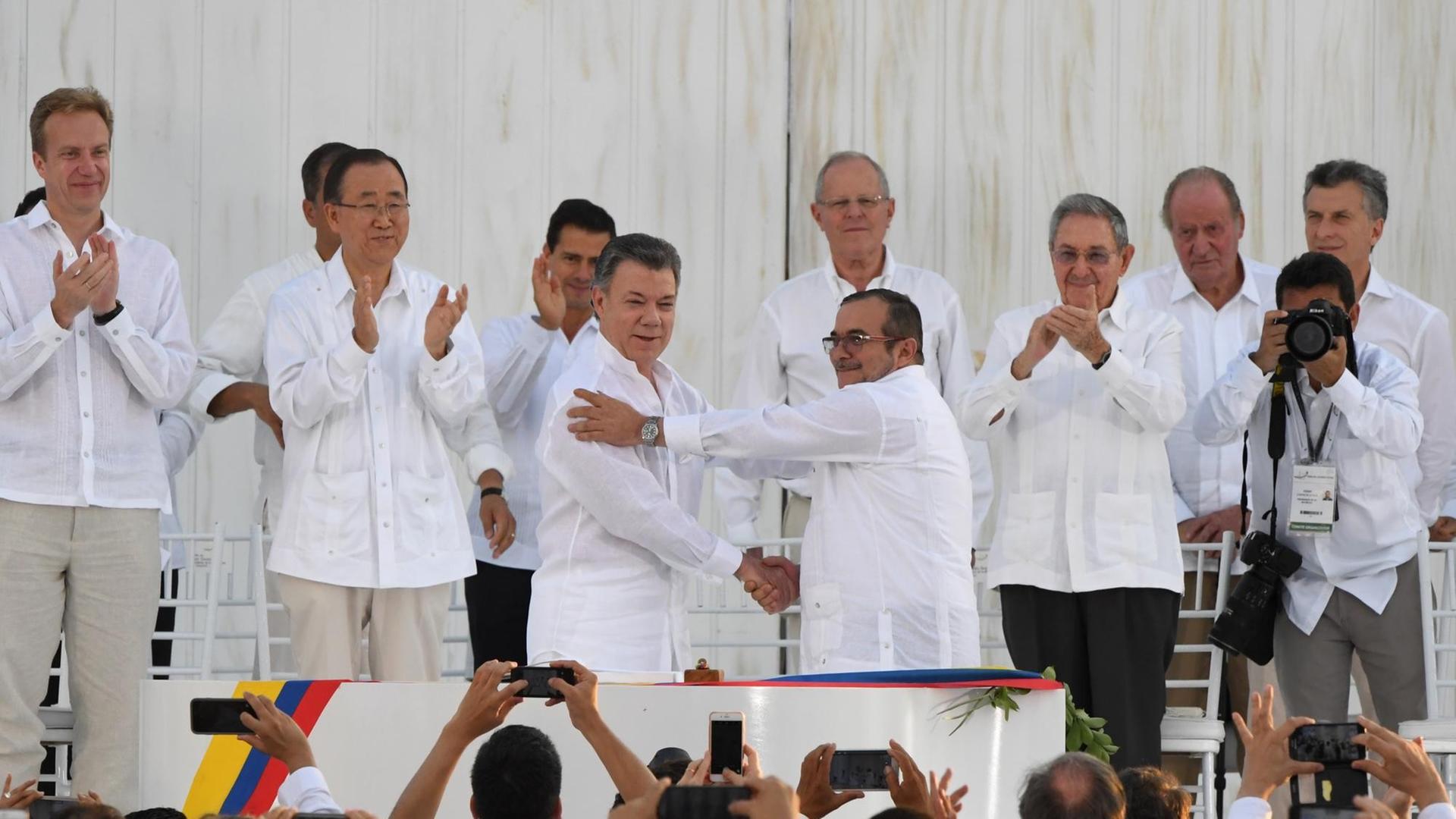 Der kolumbianische Präsident Juan Manuel Santos und der Kommandeur der FARC-Guerrilla-Organisation Timoleon Jimenez, alias Timochenko, geben sich beim Festakt in Cartagena die Hand.