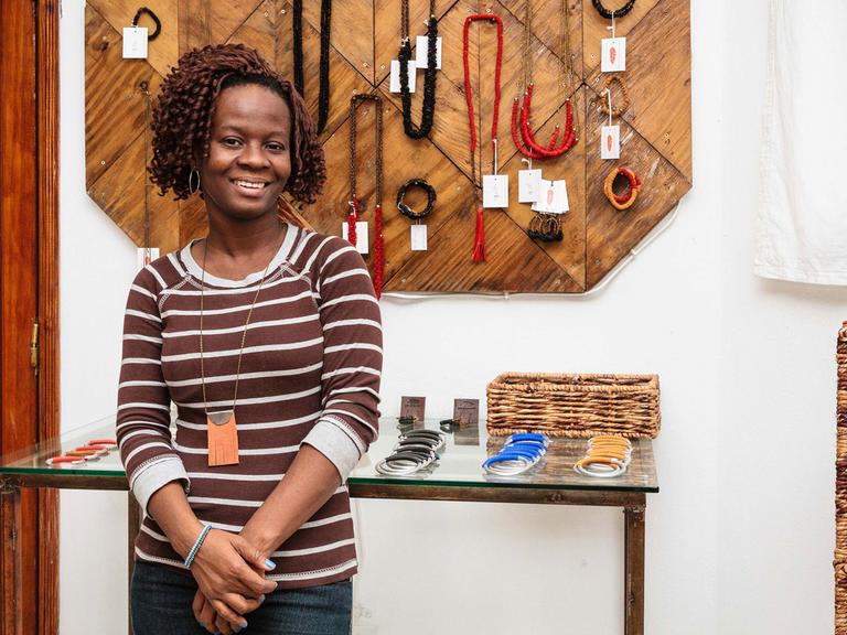 Die Buchhalterin von "Haiti Design Co-op" steht vor Produkten aus den Werkstätten. Sie fing einst als Näherin an und konnte mit dem Gehalt ihre höhere Ausbildung finanzieren.
