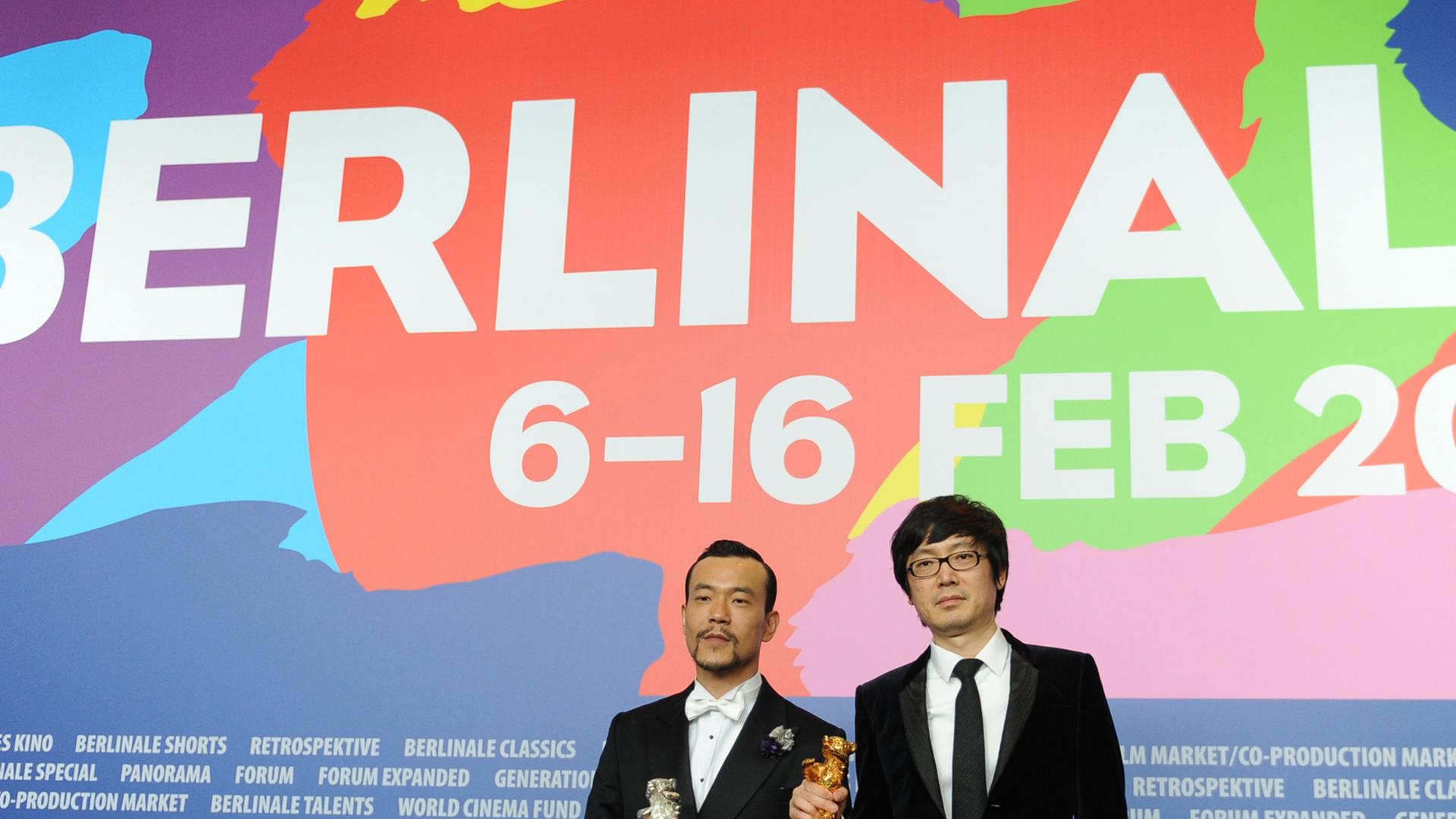Der chinesische Schaupieler Liao Fan (l.) und Regisseur Diao Yinan posieren am 15.02.2014 in Berlin auf der Pressekonferenz der Preisträger während der 64. Internationalen Filmfestspiele. Ihr Film "Bai Ri Yan Huo" (Schwarze Kohle, dünnes Eis) wurde mit dem Goldenen Bären ausgezeichnet, Liao Fan erhielt den Silbenen Bären als bester Darsteller.