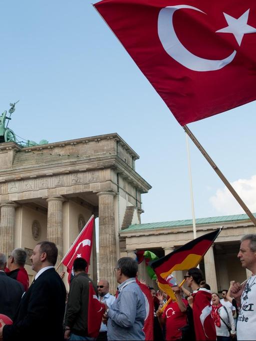 Teilnehmer einer Demonstration in Berlin schwenken türkische Flaggen vor dem Brandenburger Tor.