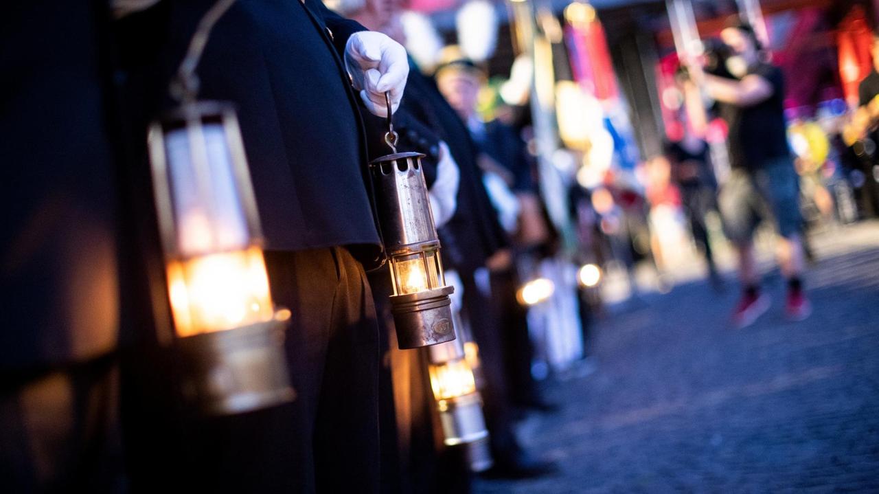 Zahlreiche ehemalige Bergleute stehen mit Grubenlampen im Rahmen des 13. Deutsche Bergmannstag und der "Extraschicht" vor der Zeche Zollverein in Essen.