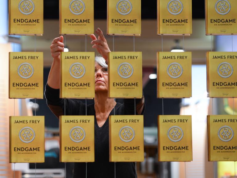 Claudia Maas richtet auf der Buchmesse in Frankfurt am Main (Hessen) am Stand der Verlagsgruppe Oetinger Exemplare von James Freys Buch "Endgame" aus.