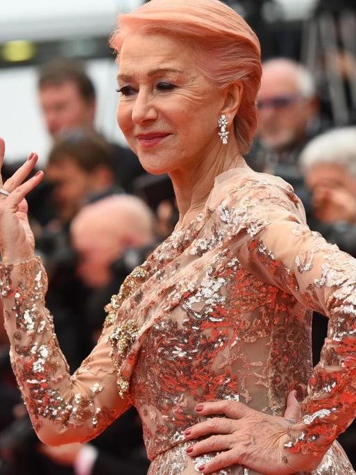 Königliche Erscheinung: Schauspielerin Helen Mirren posiert im festlichen Kleid und mit erhobener Hand vor den Fotografinnen und Fotografen bei den Filmfestspielen in Cannes 2019