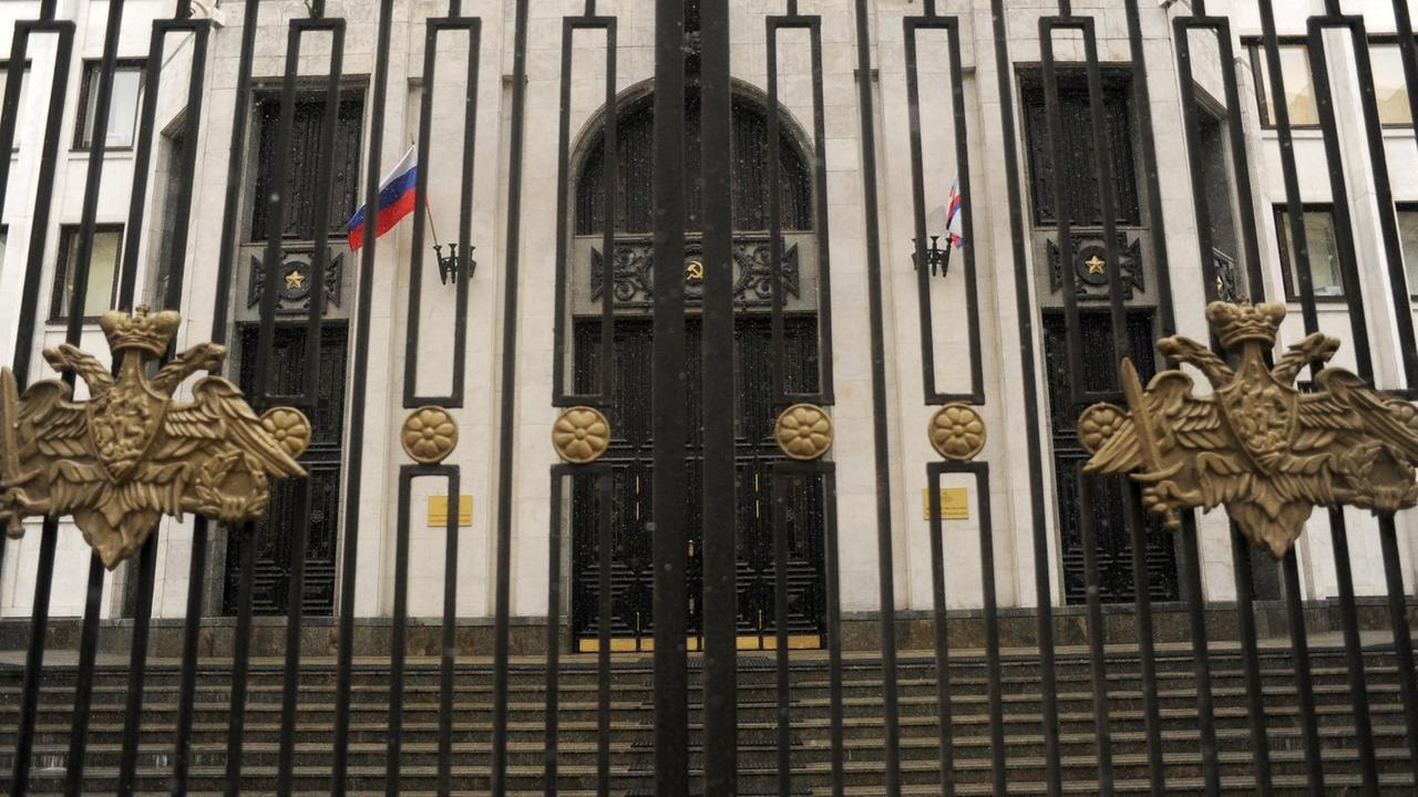 Die Frontansicht des russischen Verteidigungsministeriums. In Front ein Zaun mit vergoldeten Figuren.