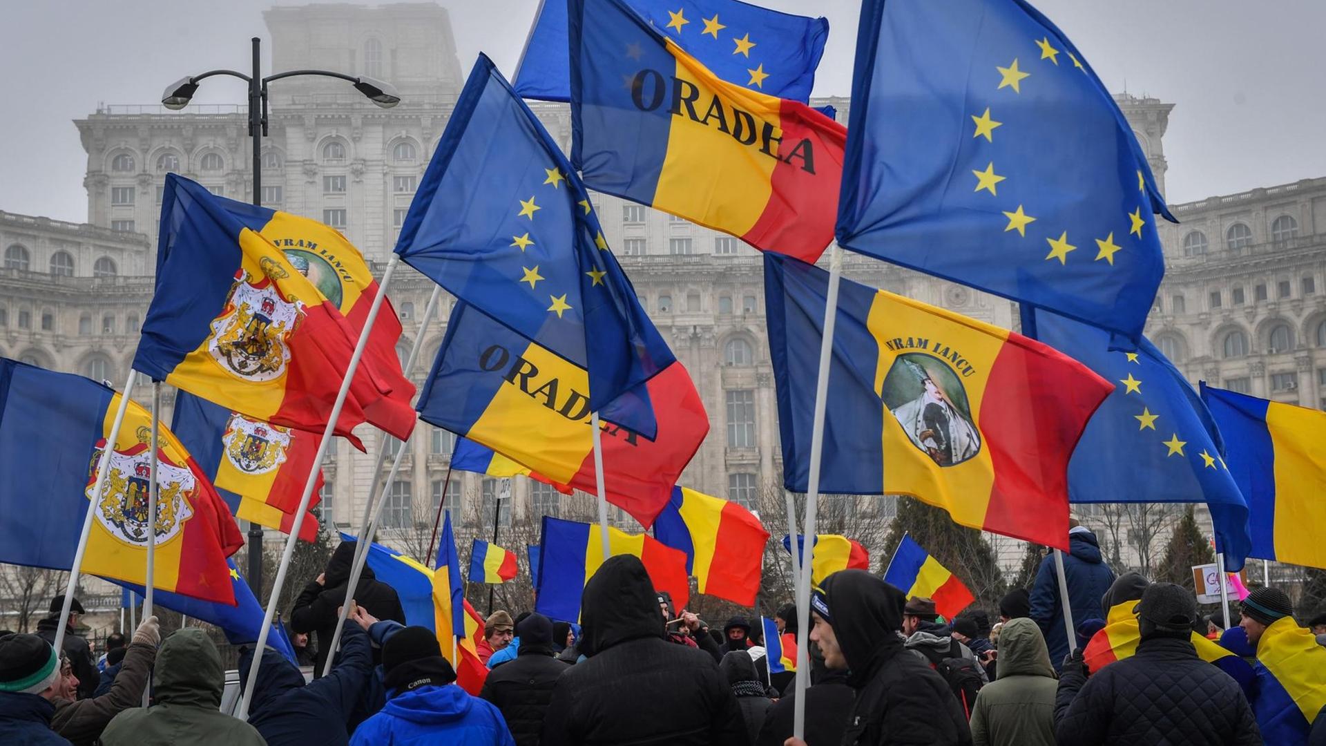 Demonstranten mit rumänischen und EU-Flaggen vor dem Parlament in Bukarest | Photo by Daniel Mihailescu / AFP