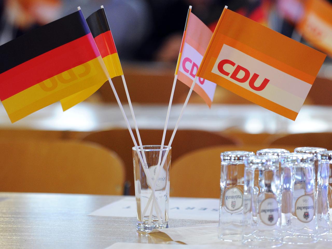 In einem Wasserglass stecken zwei kleine Deutschland- und zwei kleine CDU-Flaggen