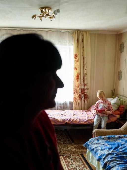 Kira Romanowa spielt im Haus der Familie in einem Dorf in der Nähe von Slowjansk in der Ostukraine und wird dabei von ihrer Mutter Nadeschda Romanova beobachtet.
