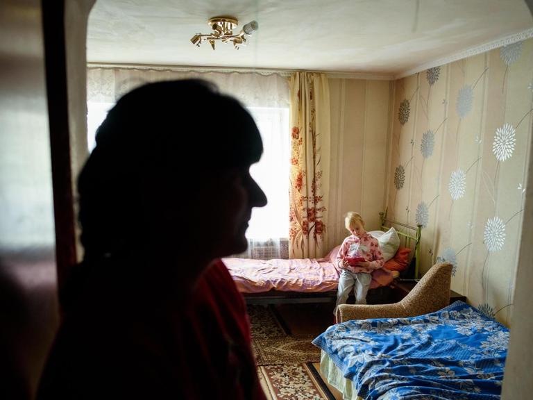 Kira Romanowa spielt im Haus der Familie in einem Dorf in der Nähe von Slowjansk in der Ostukraine und wird dabei von ihrer Mutter Nadeschda Romanova beobachtet.