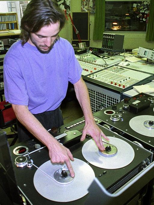 Ein DJ an Plattentellern im Studio von DT64