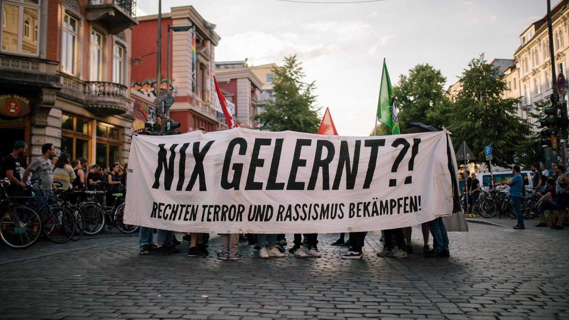 Demonstranten halten ein Spruchband mit der Aufschrift "Nix gelernt? Rechten Terror und Rassismus bekämpfen"