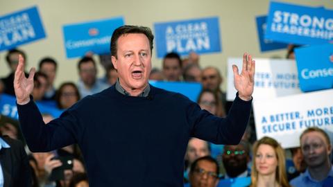 David Cameron redet am 7. März im Norden Londons auf einer Wahlkampfveranstaltung zu den Parlamentswahlen am 7. Mai. Im Hintergrund viele Wahlplakate.