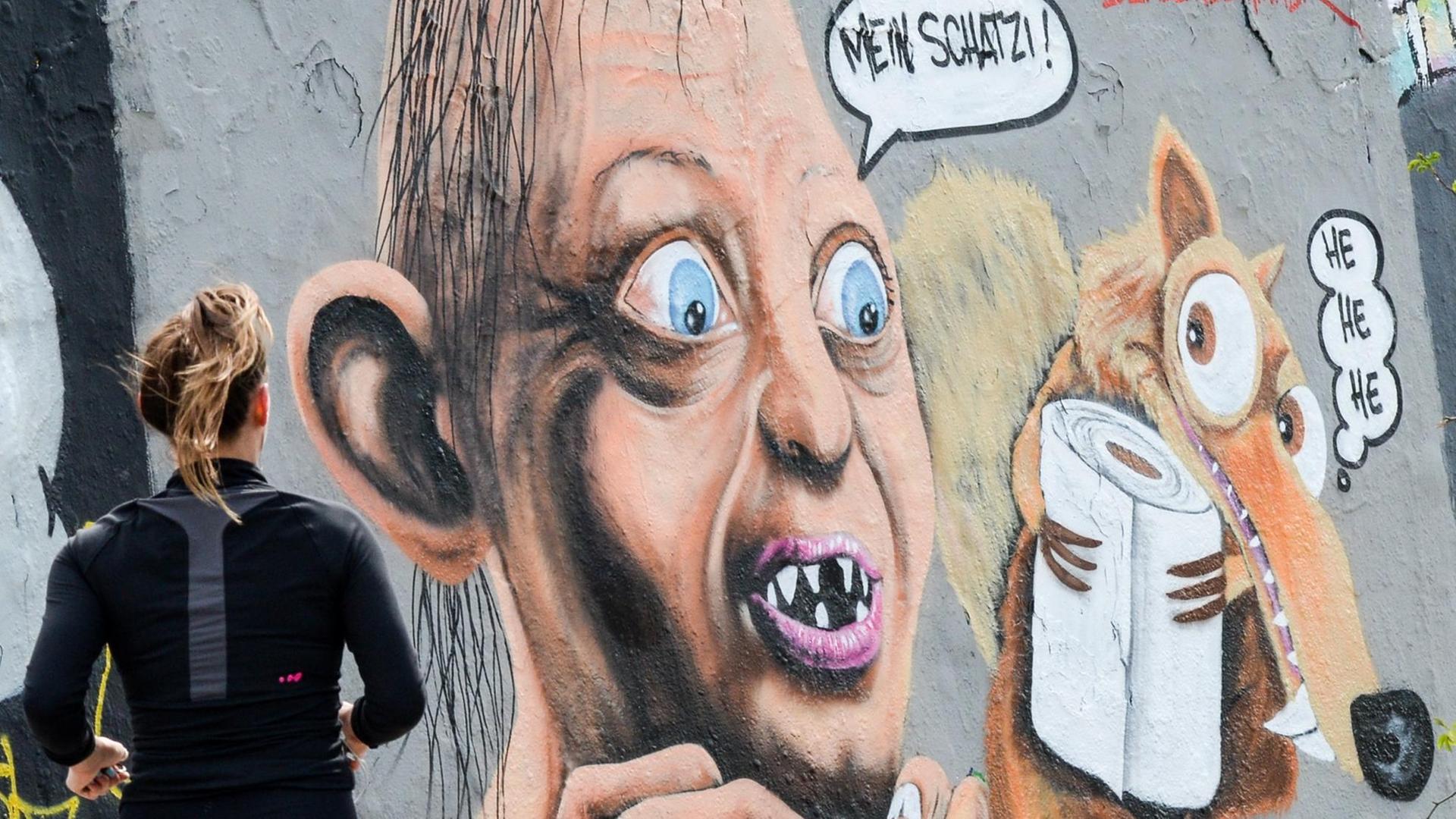 Ein Graffiti mit Gollum, einer Figur aus dem Film "Herr der Ringe" und Scrat, ein Säbelzahn-Eichhörnchen aus dem Film "Ice Age", ist an einer Wand im Mauerpark mit einer Toilettenpapierrolle zu sehen. Ein Graffiti mit Gollum, einer Figur aus dem Film "Herr der Ringe" und Scrat, ein Säbelzahn-Eichhörnchen aus dem Film "Ice Age", ist an einer Wand im Mauerpark mit einer Toilettenpapierrolle zu sehen.