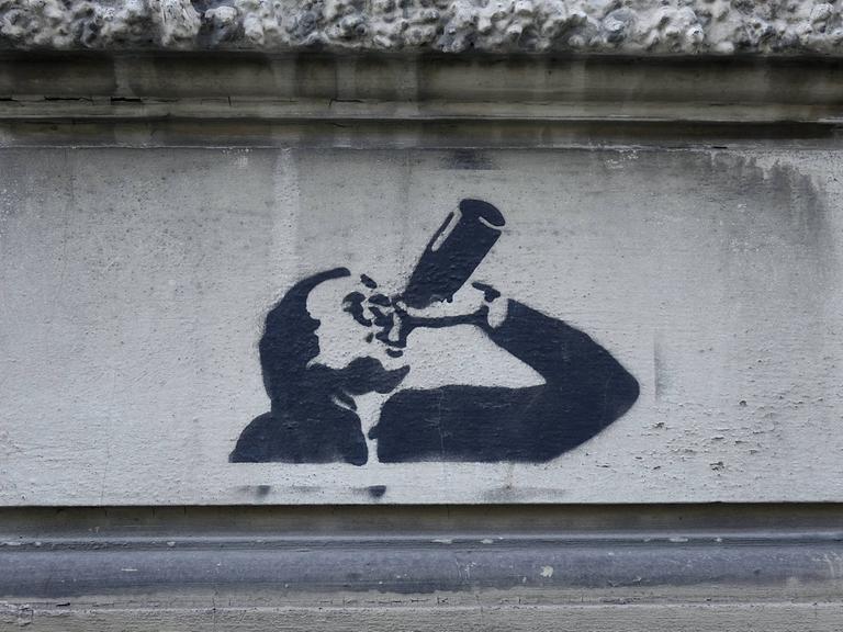 Graffiti eines Biertrinkers an einer Hauswand