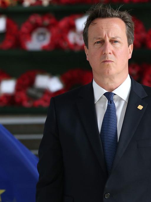 David Cameron zwischen den Flaggen Großbritanniens und der EU.