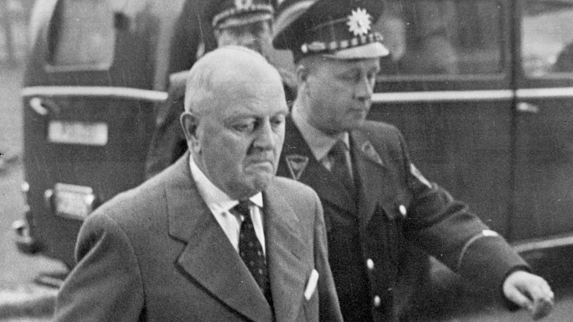 Ein Polizist begleitet den wegen Spionage angeklagten SPD-Politiker Alfred Frenzel im April 1961 zum Bundesgerichtshof in Karlsruhe