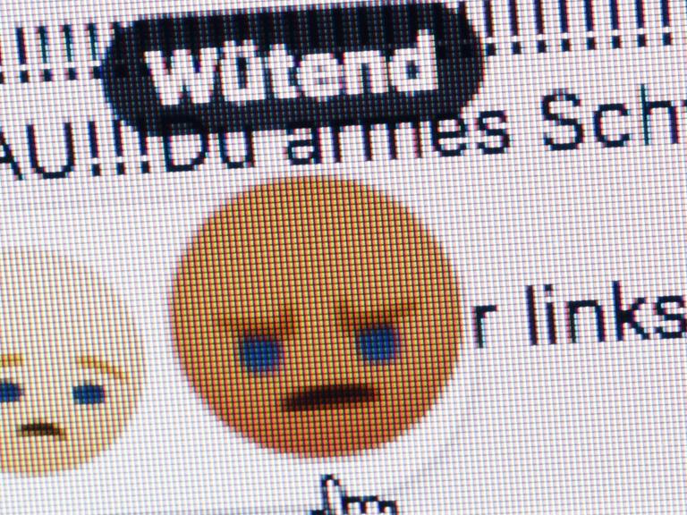 Ein wütend schauendes Emoticon bei Facebook wird mit einem Mauspfeil angeklickt.