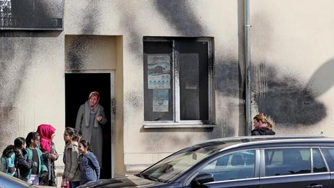 Gemeindemitglieder stehen nach einem Farbanschlag vor einer Moschee in Leipzig.