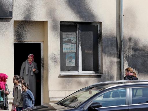 Gemeindemitglieder stehen nach einem Farbanschlag vor einer Moschee in Leipzig.