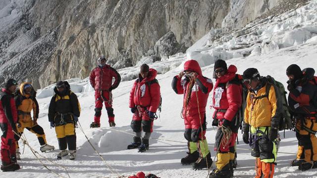 Nepalesische Sherpas stehen in einem Halbkreis um die Leiche eines Bergsteigers, der im Mai 2010 bei einer Expedition auf dem höchsten Berg der Welt ums Leben kam.