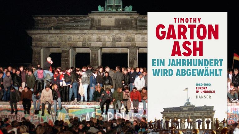 Jubelnde Menschen auf der Berliner Mauer am Brandenburger Tor am 10.11.1989.