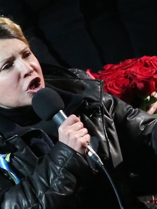 Julia Timoschenko hält im Rollstuhl sitzend eine Rede, in ihrer rechten Hand hält sie ein Mikrofon.