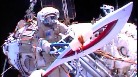 Die Olympische Fackel beim Außeneinsatz auf der Raumstation