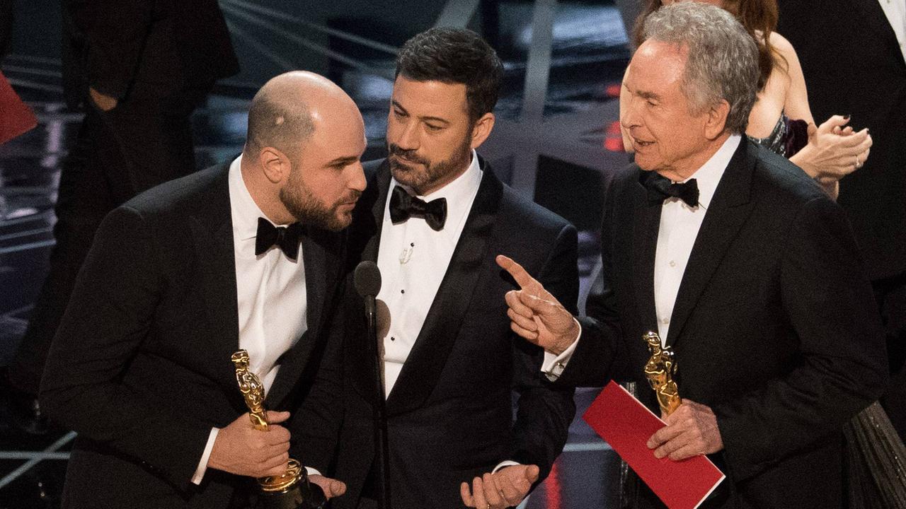 "La La Land"-Produzent Jordan Horowitz, Moderator Jimmy Kimmel und Bester-Film-Laudator Warren Beatty auf der Bühne während einer Panne bei der Verleihung der 89. Oscars. "La La Land"-Produzent Jordan Horowitz hatte irrtümlicherweise wegen einer Umschlag-Verwechselung den Oscar erhalten, der eigentlich Gewinner war dann aber: "Moonlight".