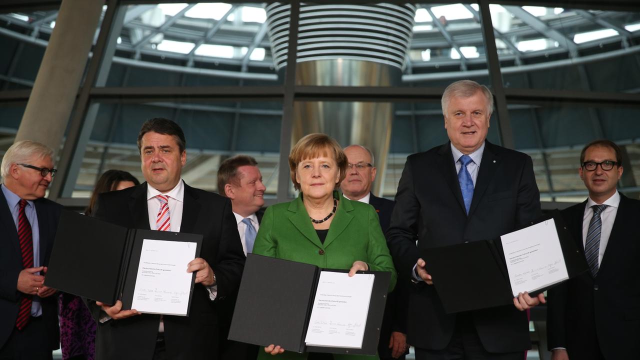 Die amtierende Bundeskanzlerin Angela Merkel (M, CDU), der CSU-Vorsitzende Horst Seehofer (r) und der SPD-Parteivorsitzende Sigmar Gabriel (l) paraphieren am 27.11.2013 im Reichstag in Berlin den Koalitionsvertrag.  Deutschland soll zum dritten Mal in sei