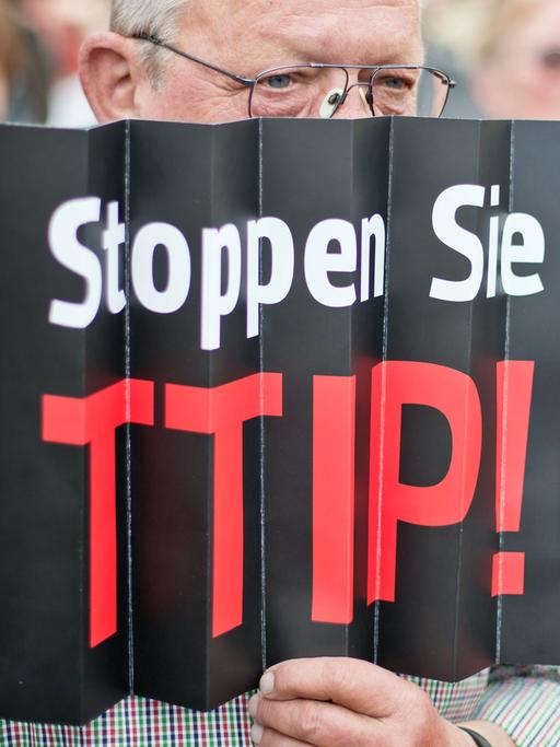 Ein Zuhörer einer Europawahlkampfveranstaltung der SPD protestiert in Nürnberg (Bayern) mit einem Plakat mit der Aufschrift "Stoppen Sie TTIP" gegen das geplante EU-US-Freihandelsabkommen TTIP.