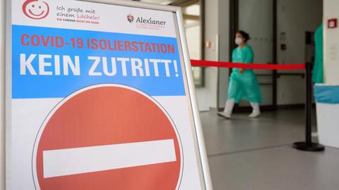 Eine Ärztin geht im St. Josefs-Krankenhaus Potsdam-Sanssouci über einen Flur der Station für an Corona erkrankte Patienten. Ein Schild verbietet den Zutritt zur Covid-19 Isolierstation