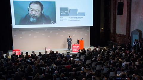 Die Künstler Olafur Eliasson (auf der Bühne) und Ai Weiwei (per Video zugeschaltet) erläutern ihr Kunstprojekt "Moon" in Berlin.