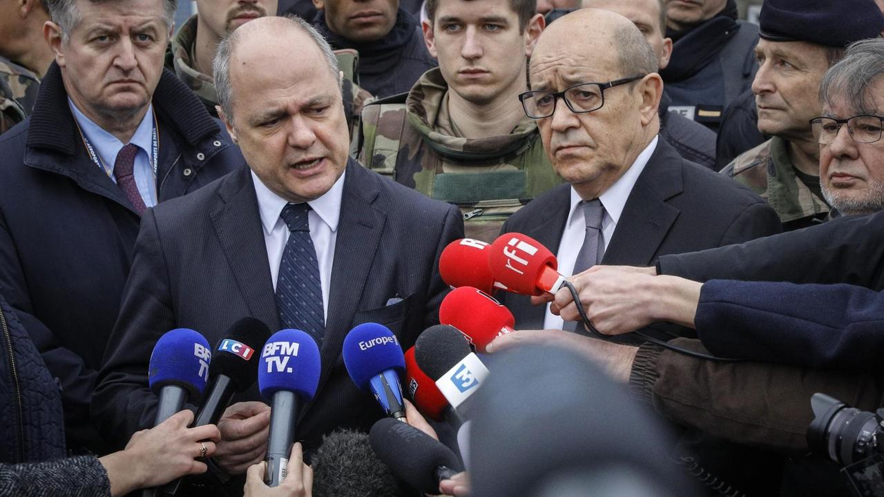 Der französische Innenminister Bruno Le Roux (l) und der Verteidigungsminister Jean-Yves Le Drian (r) vor dem Flughafen Orly.